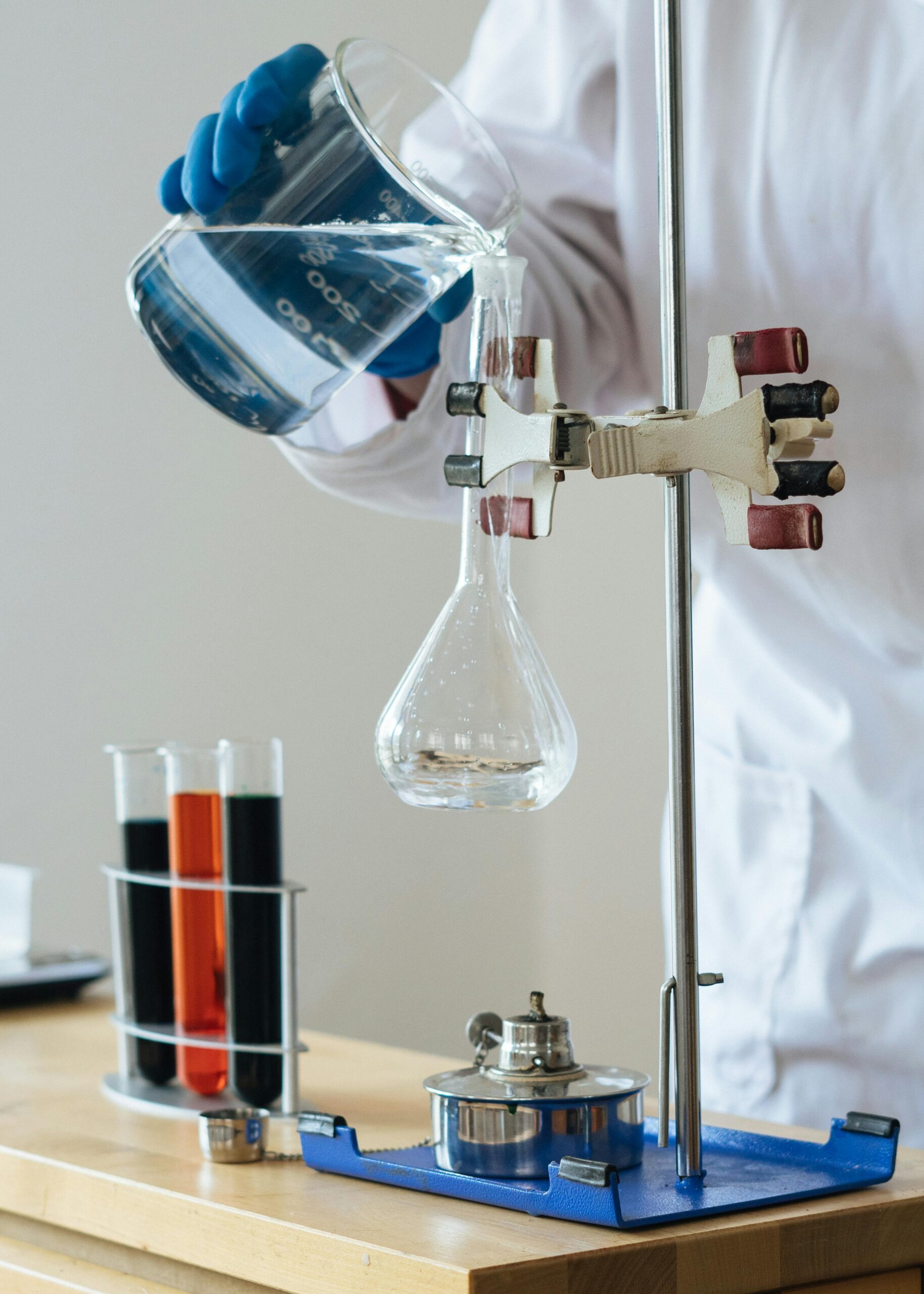 Scientist pouring liquid into a flask in a laboratory setting for research.